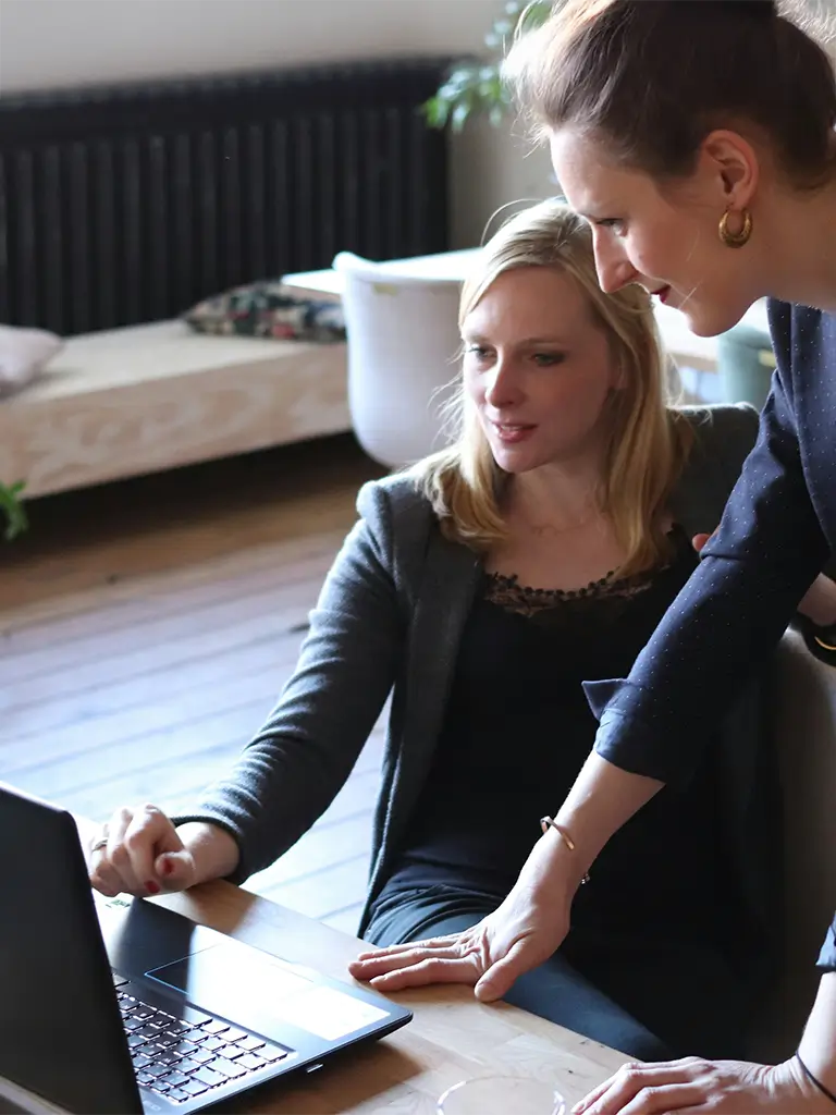 Two women looking at a laptop.