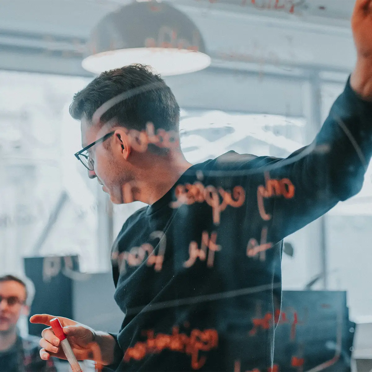 Man standing at a whiteboard with notes.